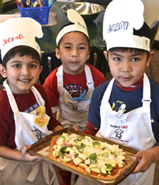Chefs Jeevan, Nathan and Aezen proudly display their pizza masterpiece. Photo by Michelle Fattore